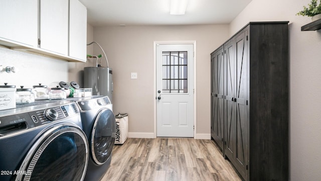 washroom featuring washer and dryer, light hardwood / wood-style floors, cabinets, and water heater