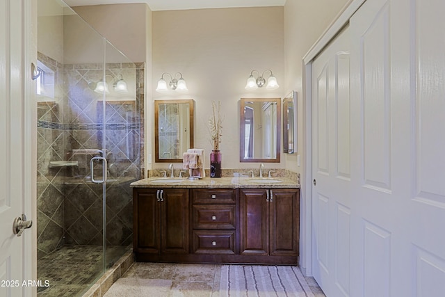 bathroom featuring double vanity, a sink, and a shower stall