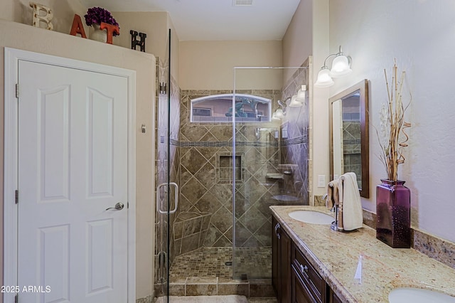 bathroom with a stall shower, visible vents, a sink, and double vanity