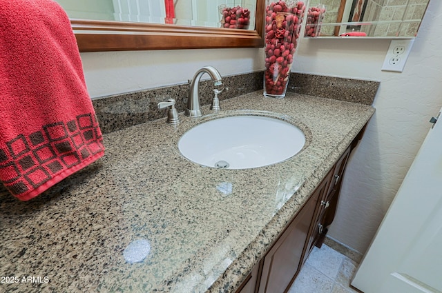 bathroom featuring a textured wall and vanity