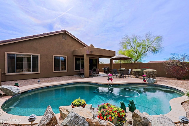 view of swimming pool featuring a fenced in pool, a fenced backyard, a patio, and grilling area