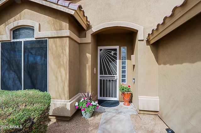 view of exterior entry with stucco siding