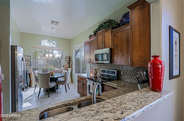 kitchen featuring tasteful backsplash, visible vents, an inviting chandelier, appliances with stainless steel finishes, and a sink