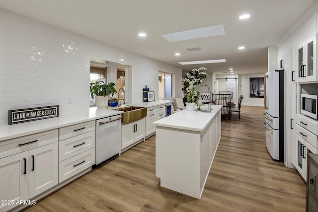 kitchen featuring white cabinetry, sink, white appliances, and a kitchen island