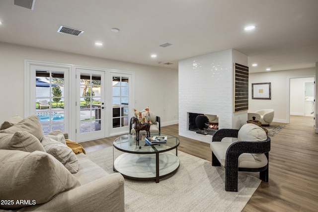 living room featuring hardwood / wood-style floors, french doors, and a fireplace