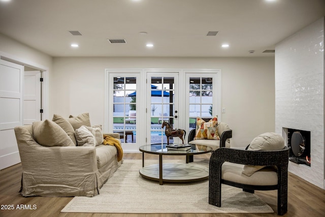 living area with a brick fireplace and dark hardwood / wood-style floors