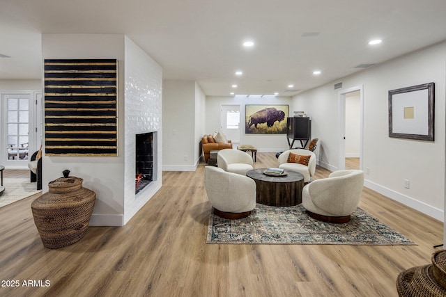 living room featuring a fireplace, hardwood / wood-style floors, and a wealth of natural light