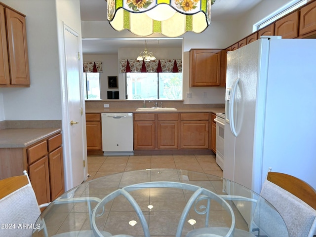 kitchen with white appliances, light tile patterned flooring, sink, and pendant lighting