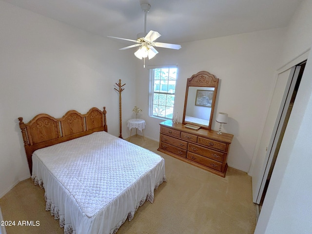 bedroom with a closet, ceiling fan, and light colored carpet