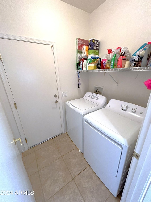 laundry area with washer and dryer and light tile patterned floors