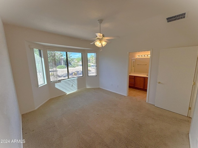 spare room featuring light colored carpet and ceiling fan