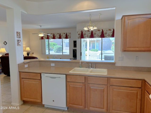 kitchen featuring white dishwasher, sink, light tile patterned floors, and plenty of natural light