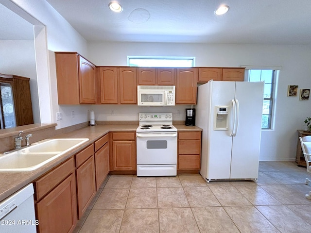 kitchen featuring light tile patterned flooring, sink, plenty of natural light, and white appliances