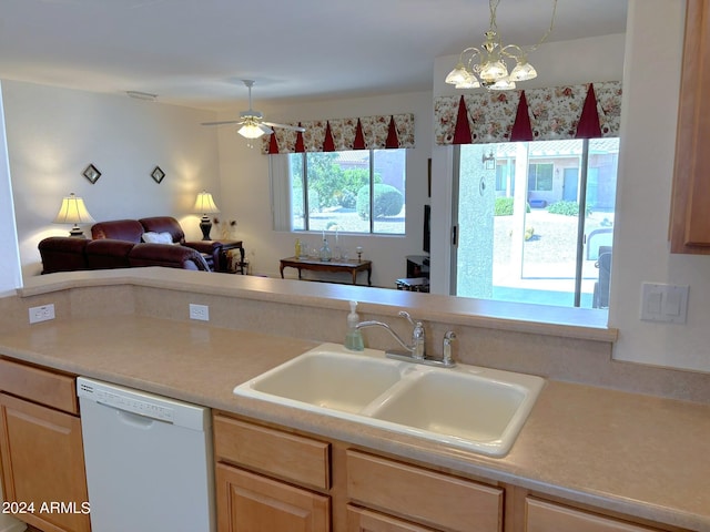 kitchen with white dishwasher, sink, light brown cabinets, and ceiling fan with notable chandelier