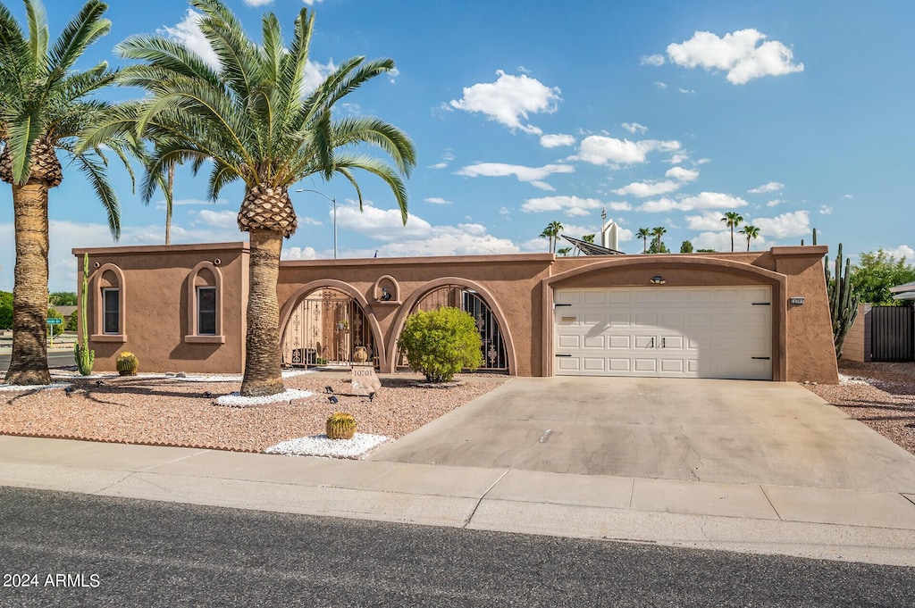 view of front of house with driveway, an attached garage, and stucco siding