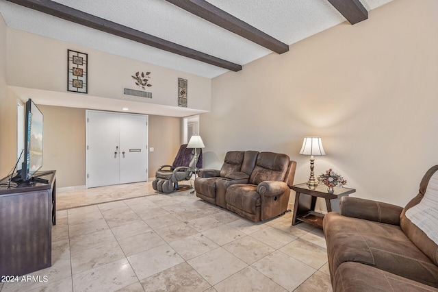 living area with a textured ceiling, visible vents, light tile patterned flooring, and beam ceiling