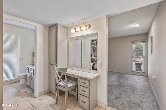 bathroom with a textured ceiling, toilet, vanity, a closet, and tile patterned floors