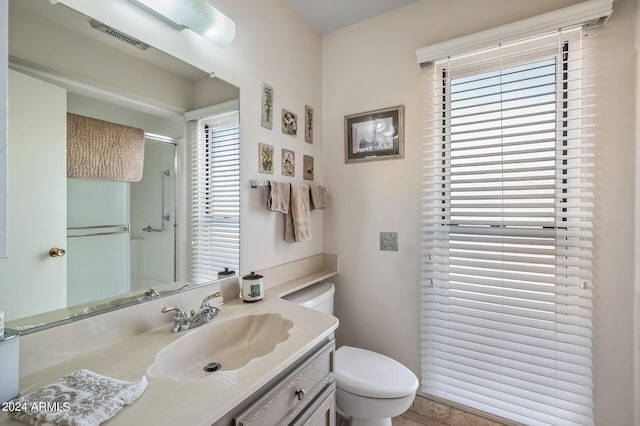 bathroom featuring toilet, a shower stall, visible vents, and vanity