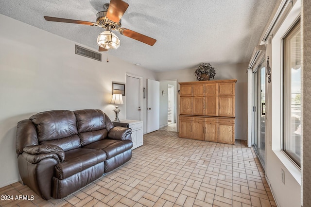 living room featuring a textured ceiling, brick floor, and visible vents