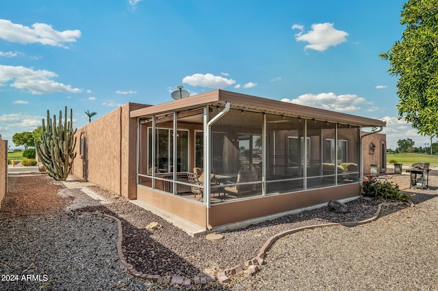 rear view of property featuring a sunroom