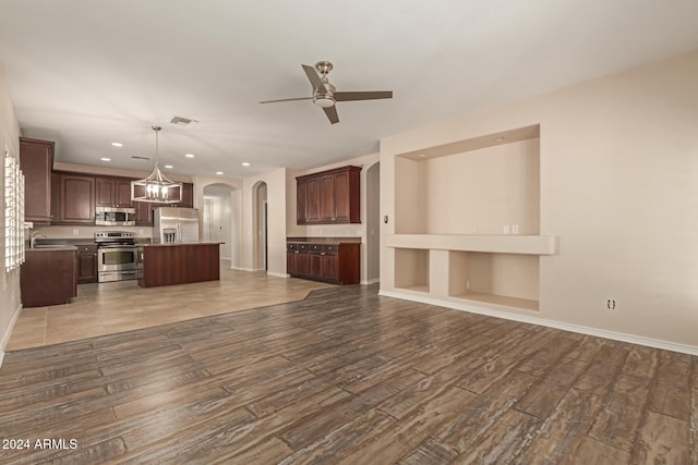 unfurnished living room featuring ceiling fan, light wood-type flooring, and sink