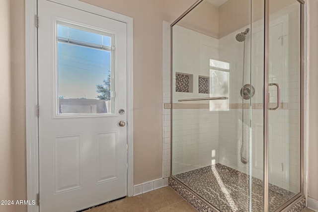 bathroom featuring tile patterned floors and a shower with shower door