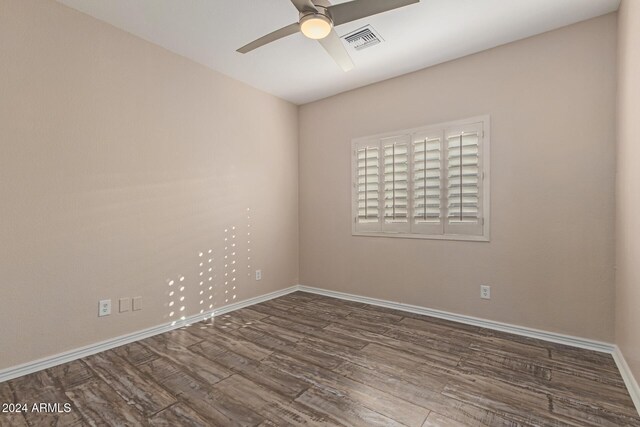 spare room featuring dark hardwood / wood-style flooring and ceiling fan