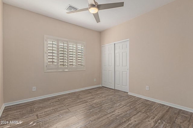 unfurnished bedroom with a closet, ceiling fan, and hardwood / wood-style floors