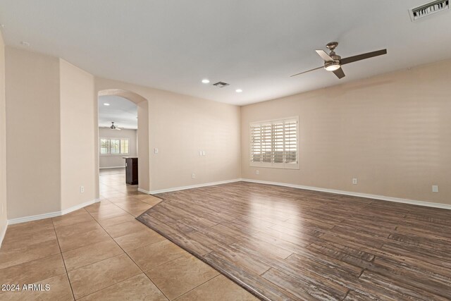 spare room with ceiling fan and light wood-type flooring