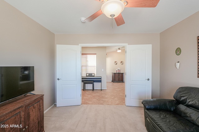 living room featuring a ceiling fan, light colored carpet, and baseboards