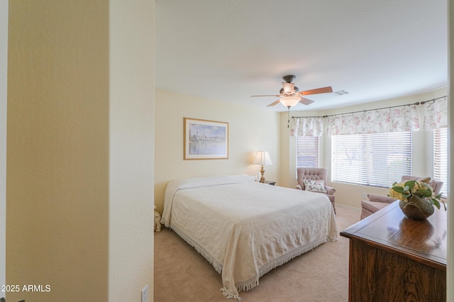 bedroom featuring a ceiling fan, light colored carpet, and visible vents