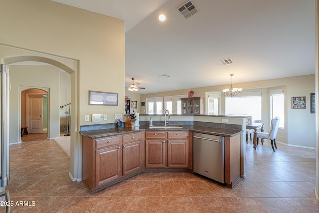 kitchen with arched walkways, visible vents, brown cabinets, stainless steel dishwasher, and a sink