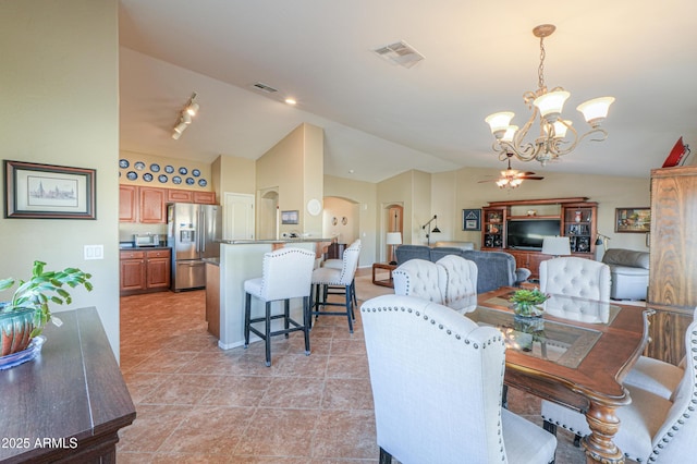 dining space featuring vaulted ceiling, light tile patterned flooring, arched walkways, and visible vents