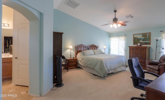 bedroom with light colored carpet, arched walkways, visible vents, and vaulted ceiling