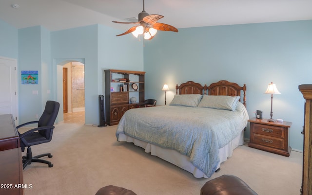 bedroom with high vaulted ceiling, light carpet, ensuite bathroom, and a ceiling fan