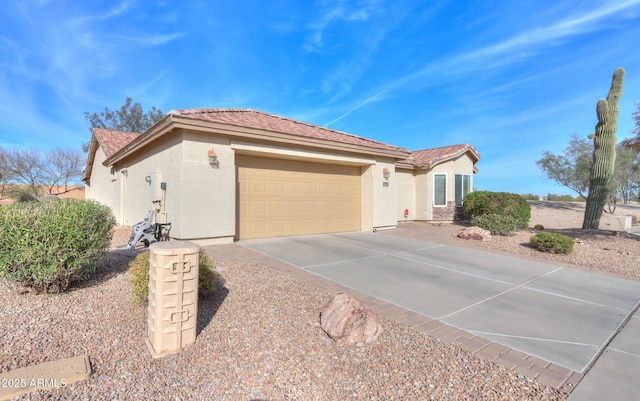 view of front of house with an attached garage, concrete driveway, and stucco siding