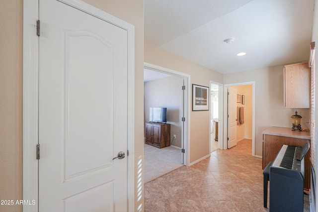 hall with recessed lighting and baseboards