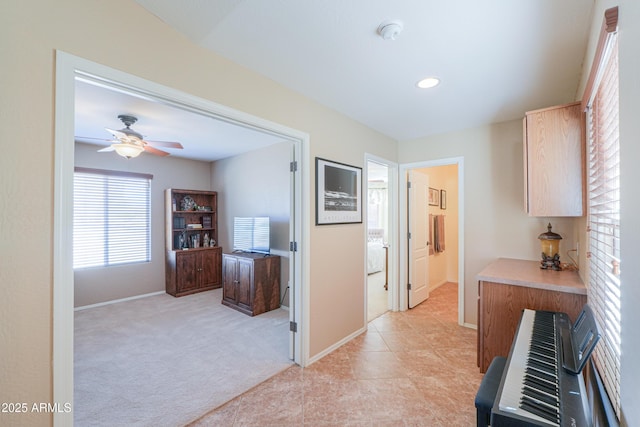 hall with heating unit, recessed lighting, baseboards, and light colored carpet