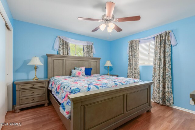 bedroom featuring wood-type flooring, multiple windows, a closet, and ceiling fan