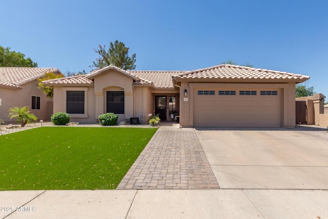 6357 W Potter Dr, Glendale, AZ 85308 - view of front of house featuring an attached garage, concrete driveway, a tile roof, a front yard, and stucco siding