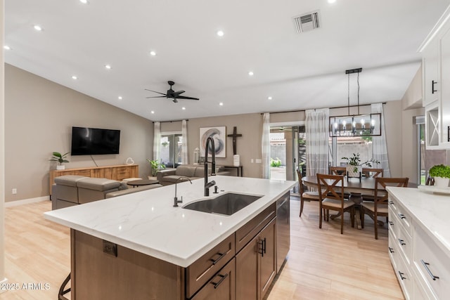 6357 W Potter Dr, Glendale, AZ 85308 - kitchen with a sink, light wood-type flooring, a kitchen island with sink, recessed lighting, and light stone counters