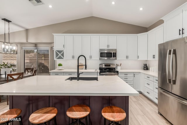 6357 W Potter Dr, Glendale, AZ 85308 - kitchen with appliances with stainless steel finishes, a sink, a kitchen breakfast bar, a chandelier, and a center island with sink