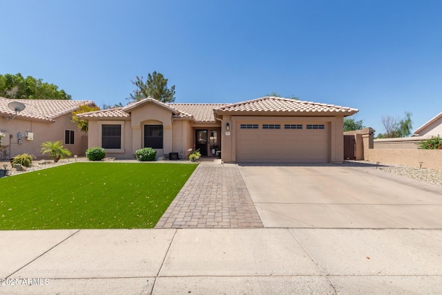 6357 W Potter Dr, Glendale, AZ 85308 - mediterranean / spanish house featuring a garage, stucco siding, a tiled roof, and a front yard
