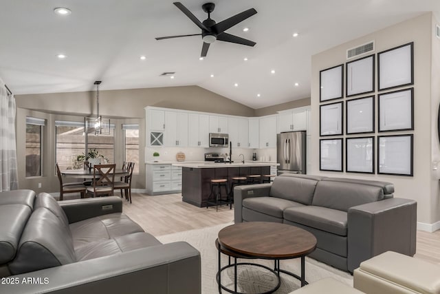 6357 W Potter Dr, Glendale, AZ 85308 - living room with ceiling fan, light wood-style flooring, vaulted ceiling, baseboards, and recessed lighting