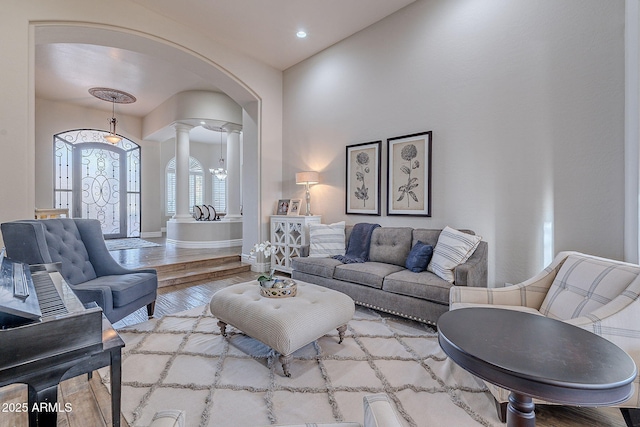 living room with ornate columns and light hardwood / wood-style floors