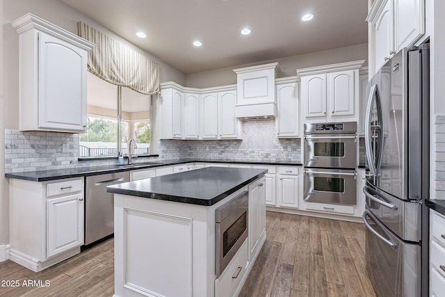 kitchen featuring white cabinetry, sink, a kitchen island, and stainless steel appliances