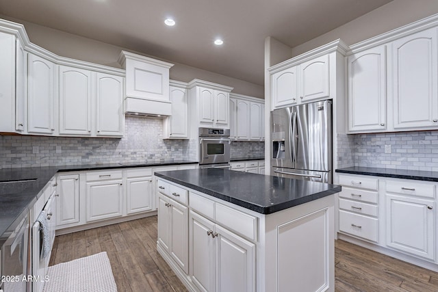 kitchen featuring hardwood / wood-style floors, decorative backsplash, white cabinetry, and stainless steel appliances