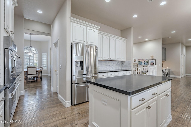 kitchen with a chandelier, white cabinetry, a kitchen island, and stainless steel appliances