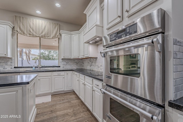 kitchen featuring white cabinetry, sink, and light hardwood / wood-style flooring