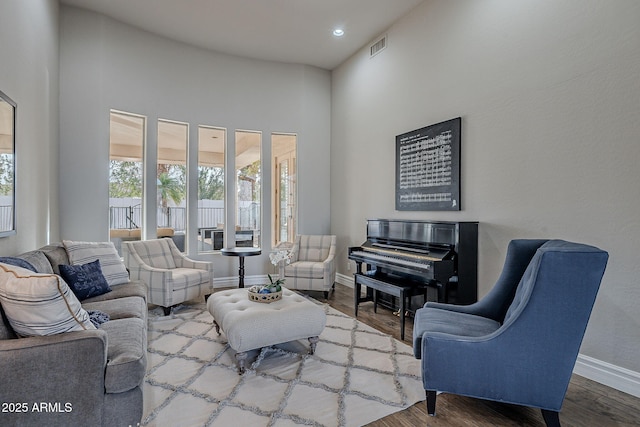 living room featuring hardwood / wood-style floors and a towering ceiling